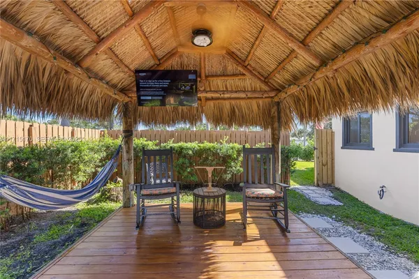 a view of a patio with table and chairs potted plants with wooden floor