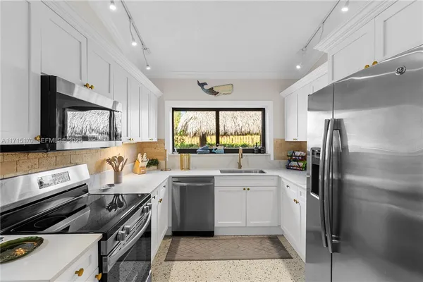 a kitchen with a sink appliances and cabinets