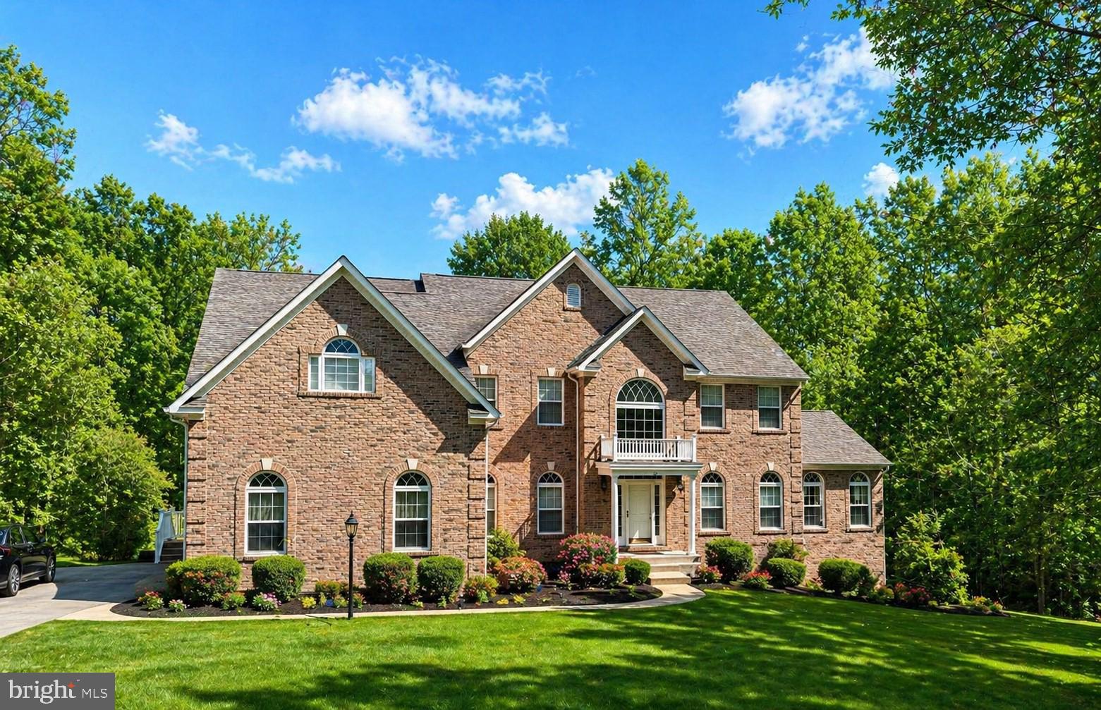 a front view of a house with a yard and trees