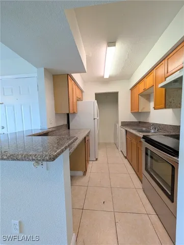 a kitchen with stainless steel appliances granite countertop a sink and a stove