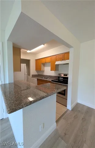 a kitchen with stainless steel appliances granite countertop a sink and a stove