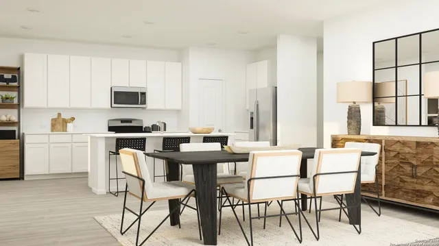 a dining room with furniture and a kitchen area