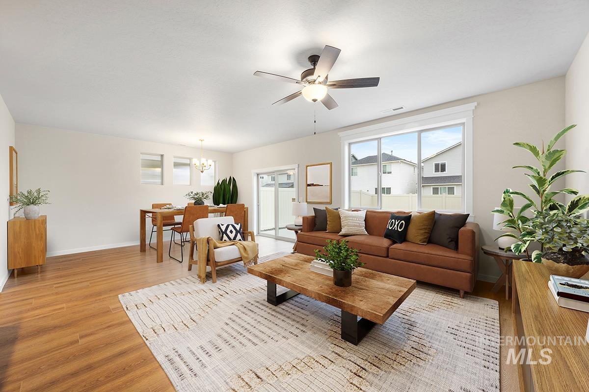 212 West Broyhill Street Meridian, ID 83642 - Photo 6 of 22 Living room featuring light wood-style flooring, ceiling fan, and a chandelier