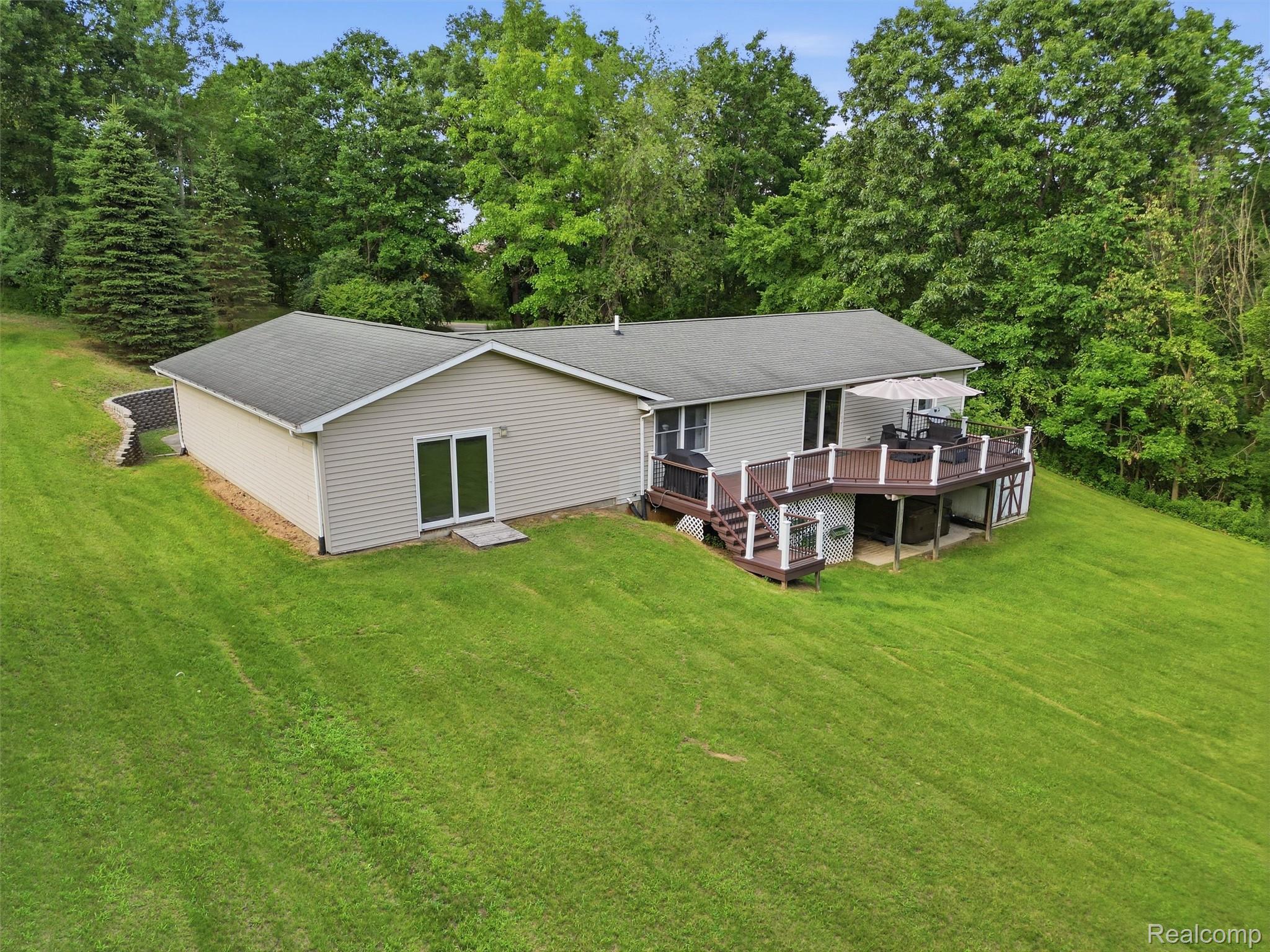 5003 Mason Road Howell, MI 48843 - Photo 52 of 59 Ranch-style residence featuring light-colored siding, a dark roof, and a multi-level deck with white railings