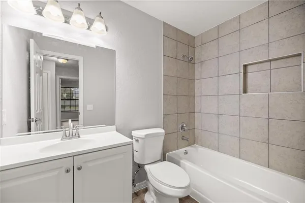 a bathroom with a toilet a sink a mirror a bathtub and shower