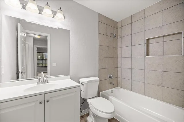 a bathroom with a toilet a sink a mirror a bathtub and shower