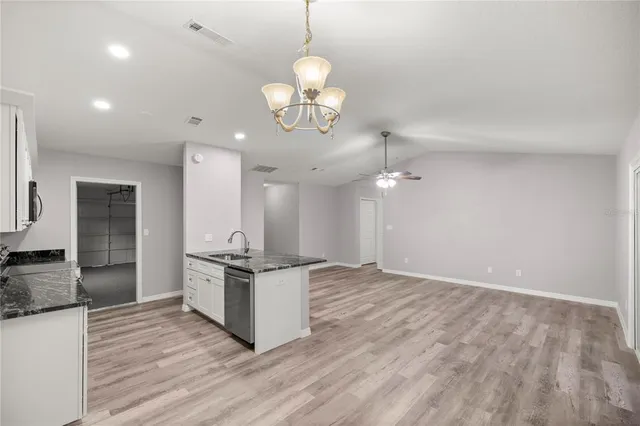 a kitchen with kitchen island stainless steel appliances a stove top oven and chandelier