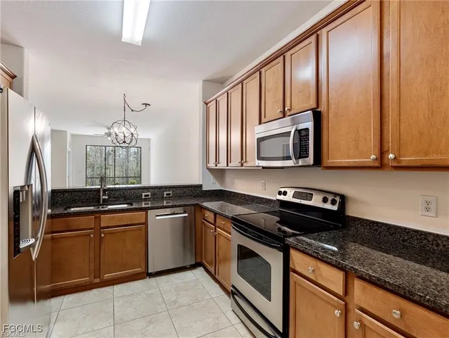 a kitchen with stainless steel appliances granite countertop a sink stove and microwave