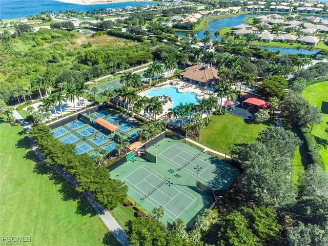 an aerial view of residential houses with outdoor space and trees