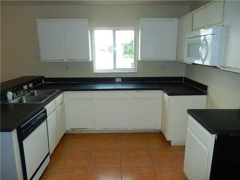 10323 Southwest 24th Street Miramar, FL 33025 - Photo 6 of 21 a kitchen with a sink a stove and cabinets