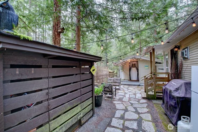 a backyard of a house with barbeque oven table and chairs