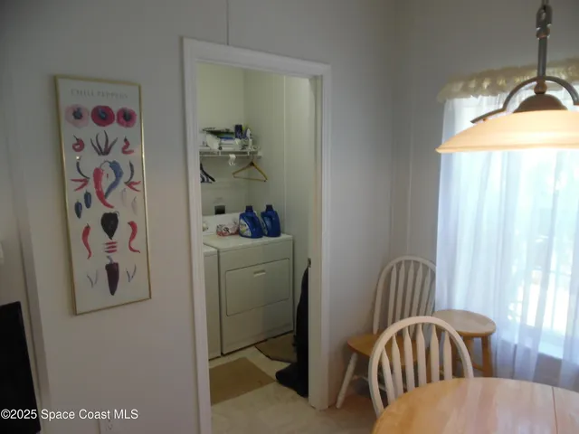 a dining room with furniture a chandelier and window