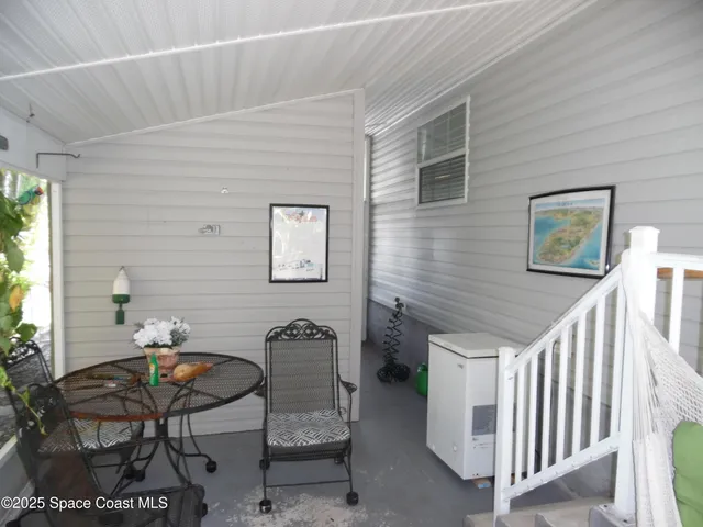 a balcony with furniture and a potted plant