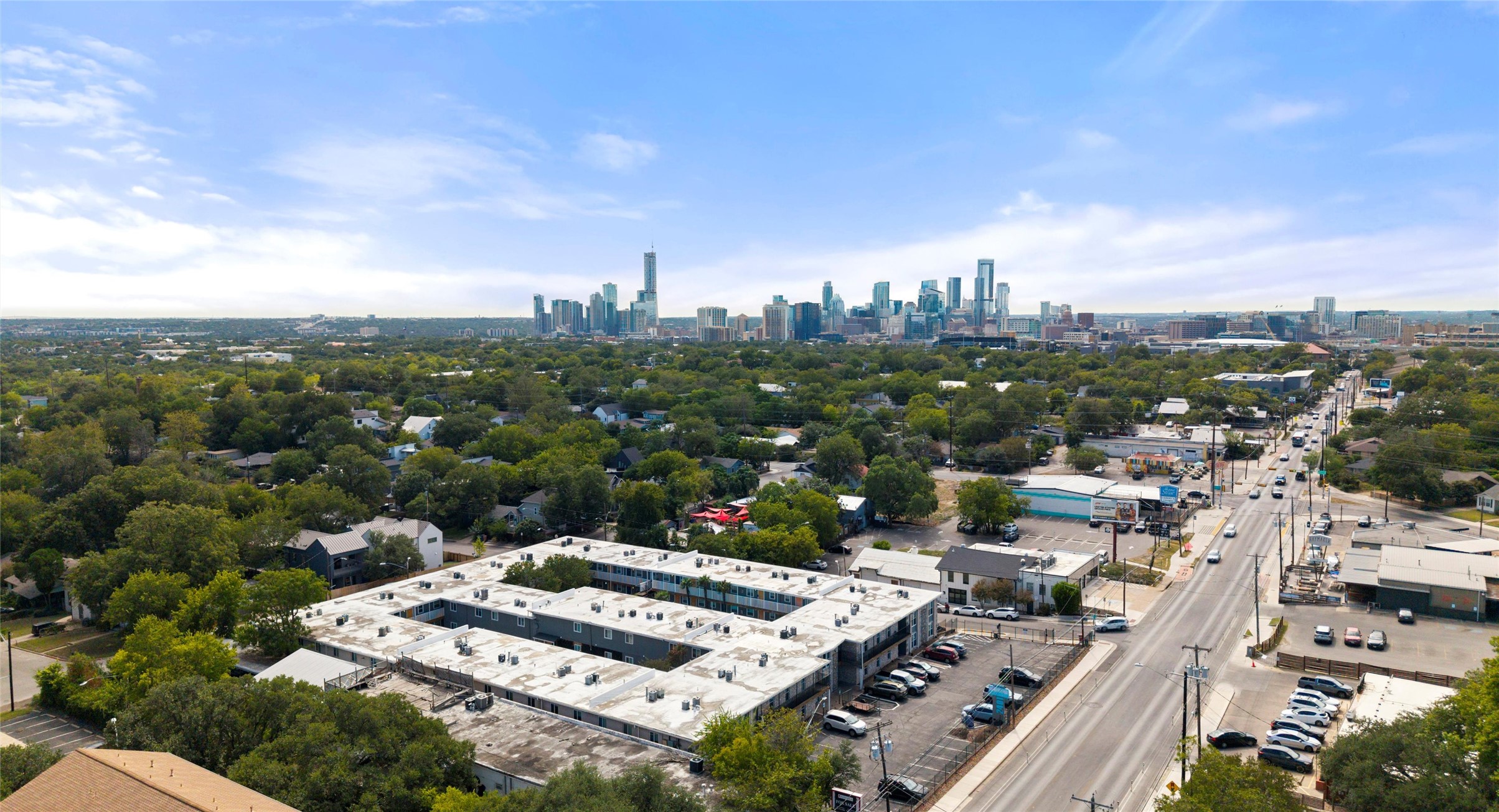 2401 Manor Road, Unit 123 Austin, TX 78722 - Photo 20 of 22 An aerial panorama reveals a vast urban landscape framed by a distant, dynamic city skyline.