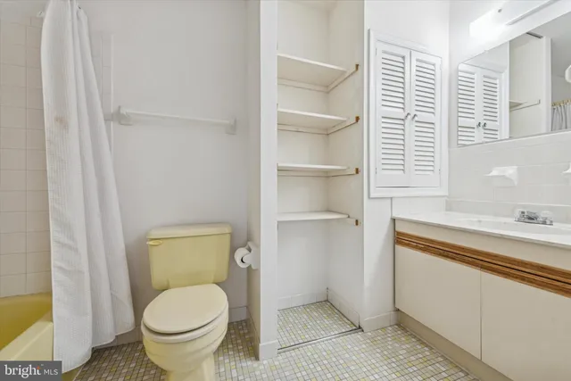 a bathroom with a granite countertop toilet and a sink