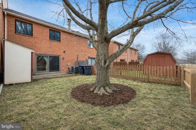 a view of a house with a small yard and wooden fence