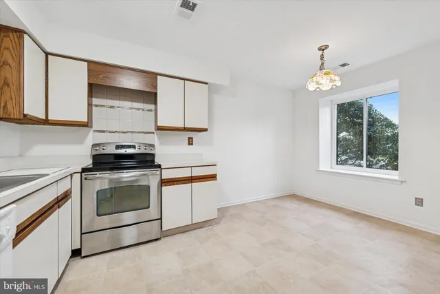a kitchen with granite countertop a stove a sink and a microwave
