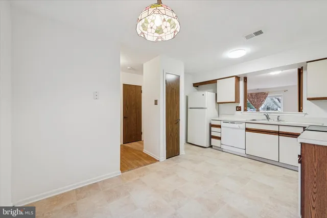 a view of a kitchen with a sink and refrigerator