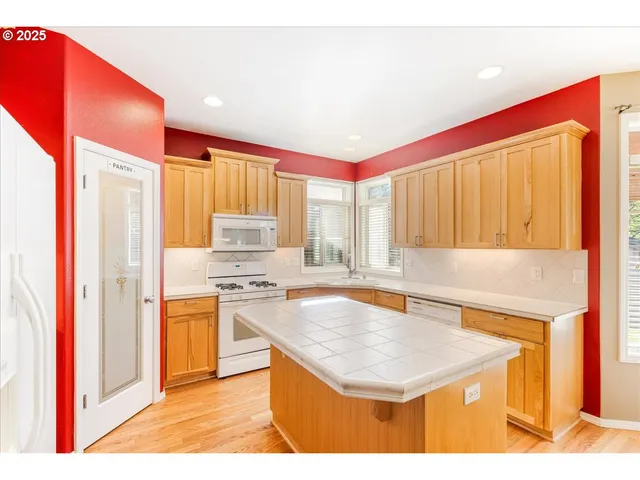 a kitchen with stainless steel appliances granite countertop a sink and a refrigerator