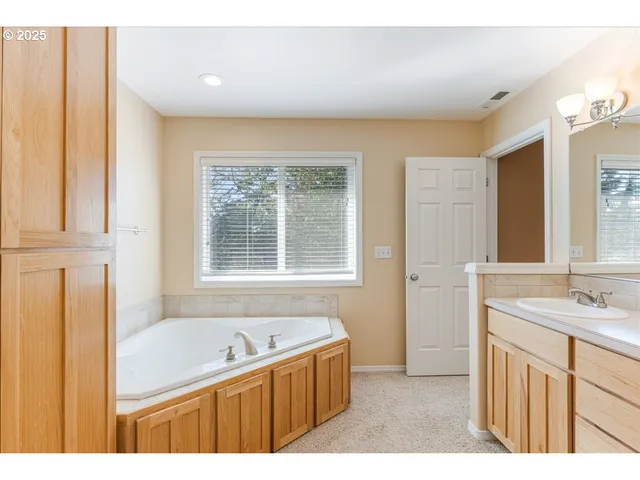 a bathroom with a tub sink and mirror
