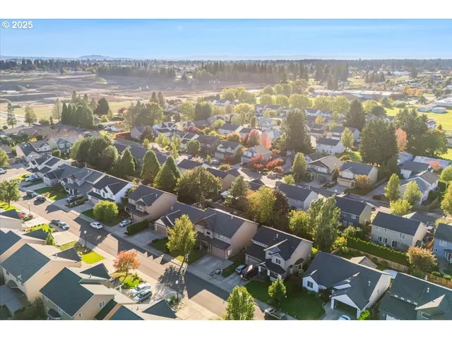 an aerial view of ocean and residential houses with outdoor space