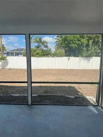 a view of an empty room with a floor to ceiling window and an outdoor view