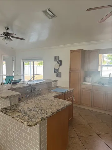 a kitchen with granite countertop a sink a stove and cabinets