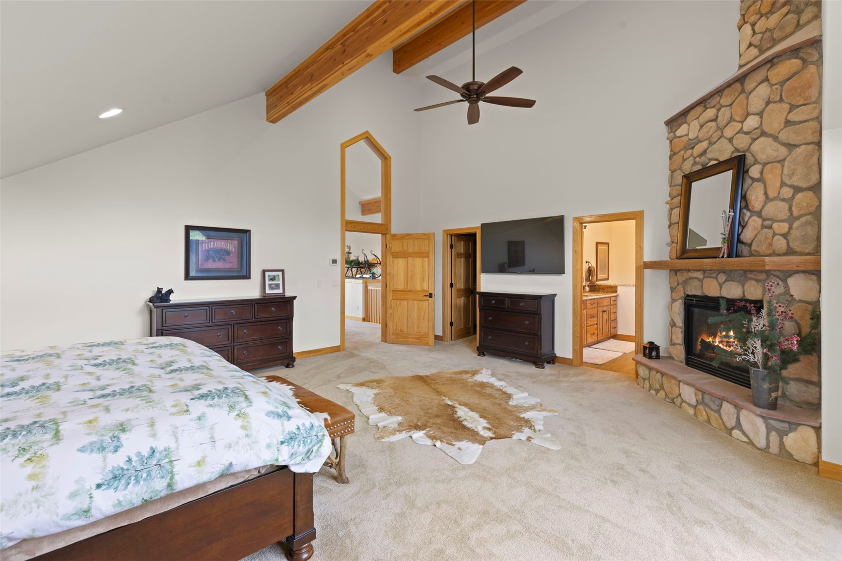 736 Wild Rose Road Silverthorne, CO 80498 - Photo 26 of 49 Bedroom featuring a stone fireplace, light carpet, beamed ceiling, high vaulted ceiling, and ensuite bathroom