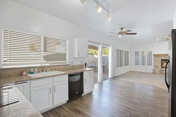 a kitchen with a sink appliances cabinets and a large window