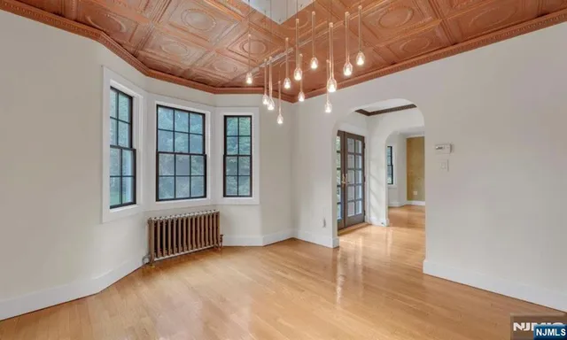 a view of an empty room with chandelier and a window