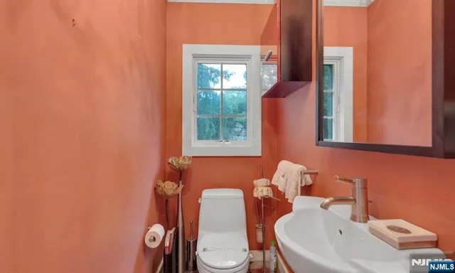 a bathroom with a toilet sink and mirror