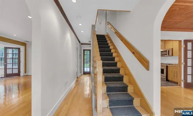 a view of staircase with lots of frames on wall and wooden floor