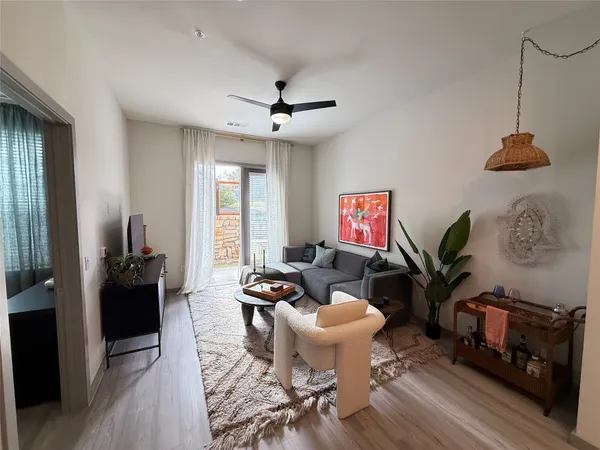 a living room with furniture a rug and a window