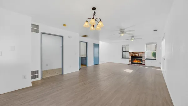 a view of empty room with a window and chandelier