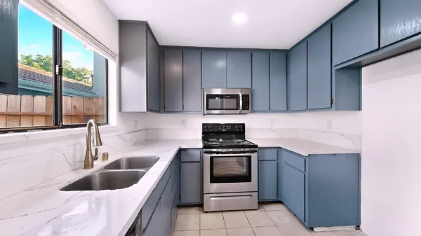 a kitchen with a sink stove top oven and cabinets