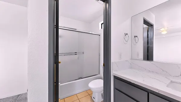 a bathroom with a granite countertop sink toilet and shower