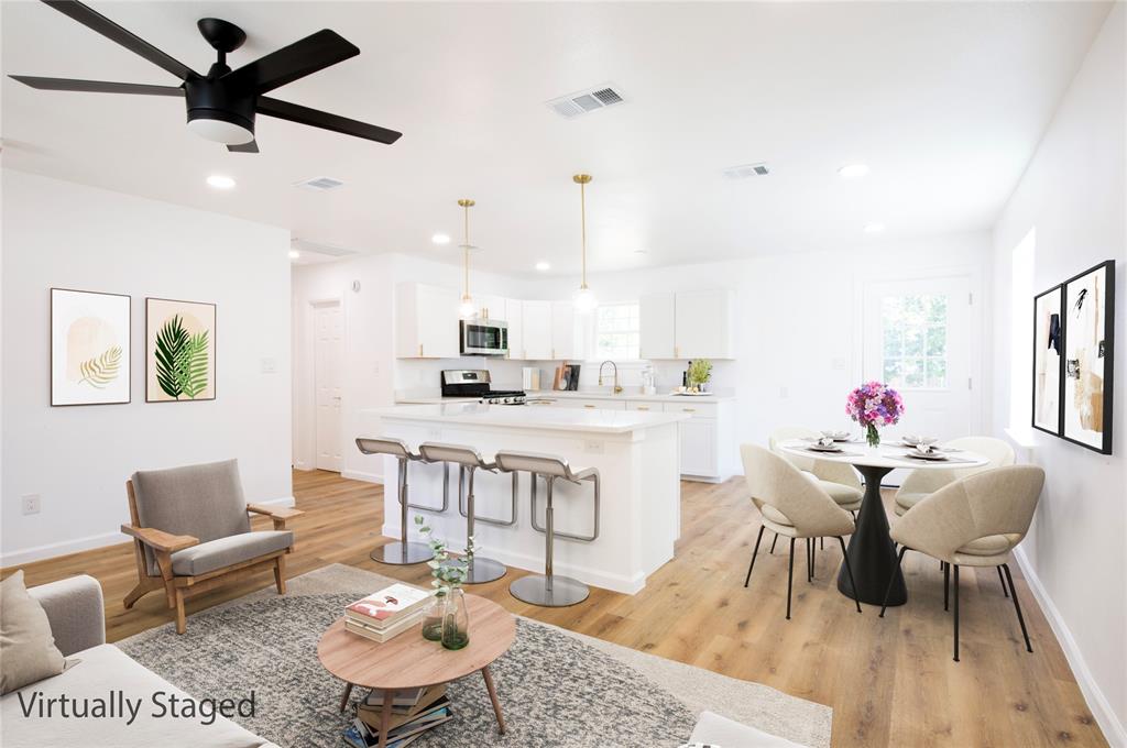 1210 Record Crossing Road Dallas, TX 75235 - Photo 1 of 1 a kitchen with a dining table chairs sink and white cabinets