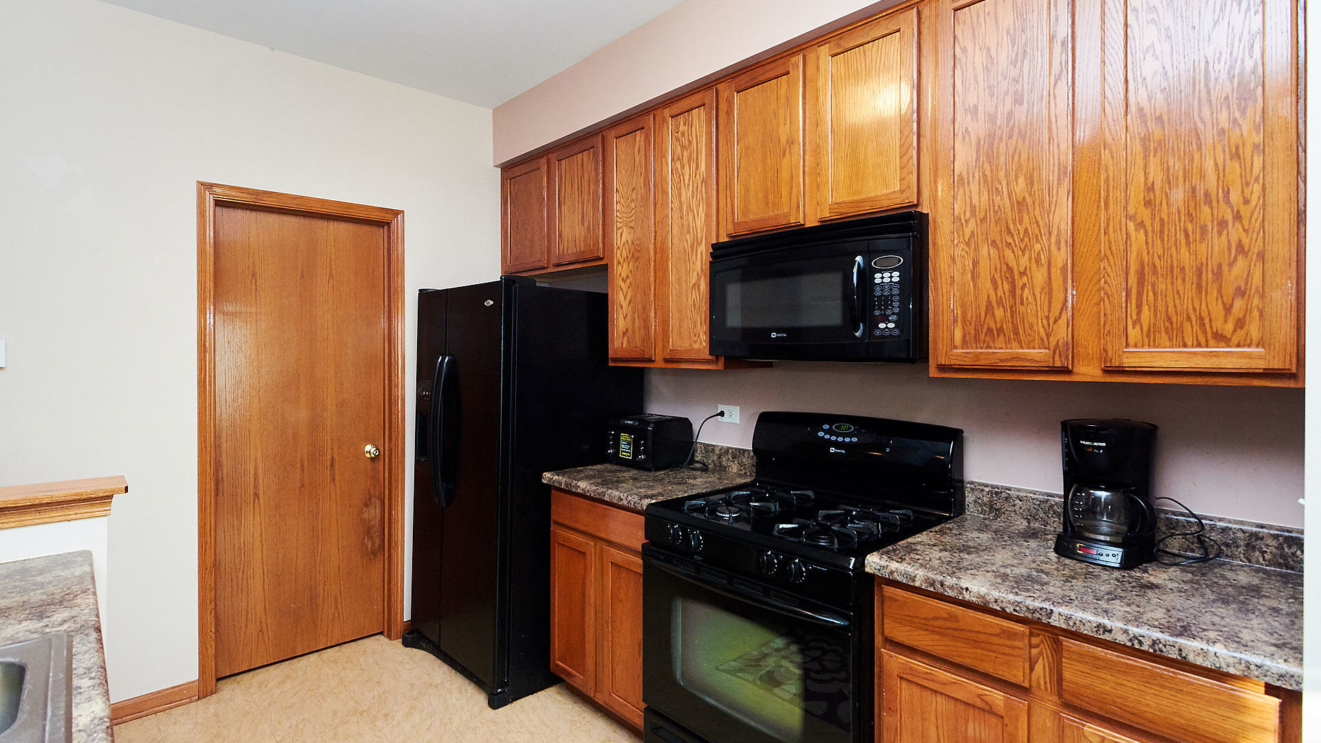 1989 West Cobblestone Road, Unit 1989 Romeoville, IL 60446 - Photo 14 of 51 a kitchen with granite countertop stainless steel appliances a refrigerator a stove a sink and cabinets
