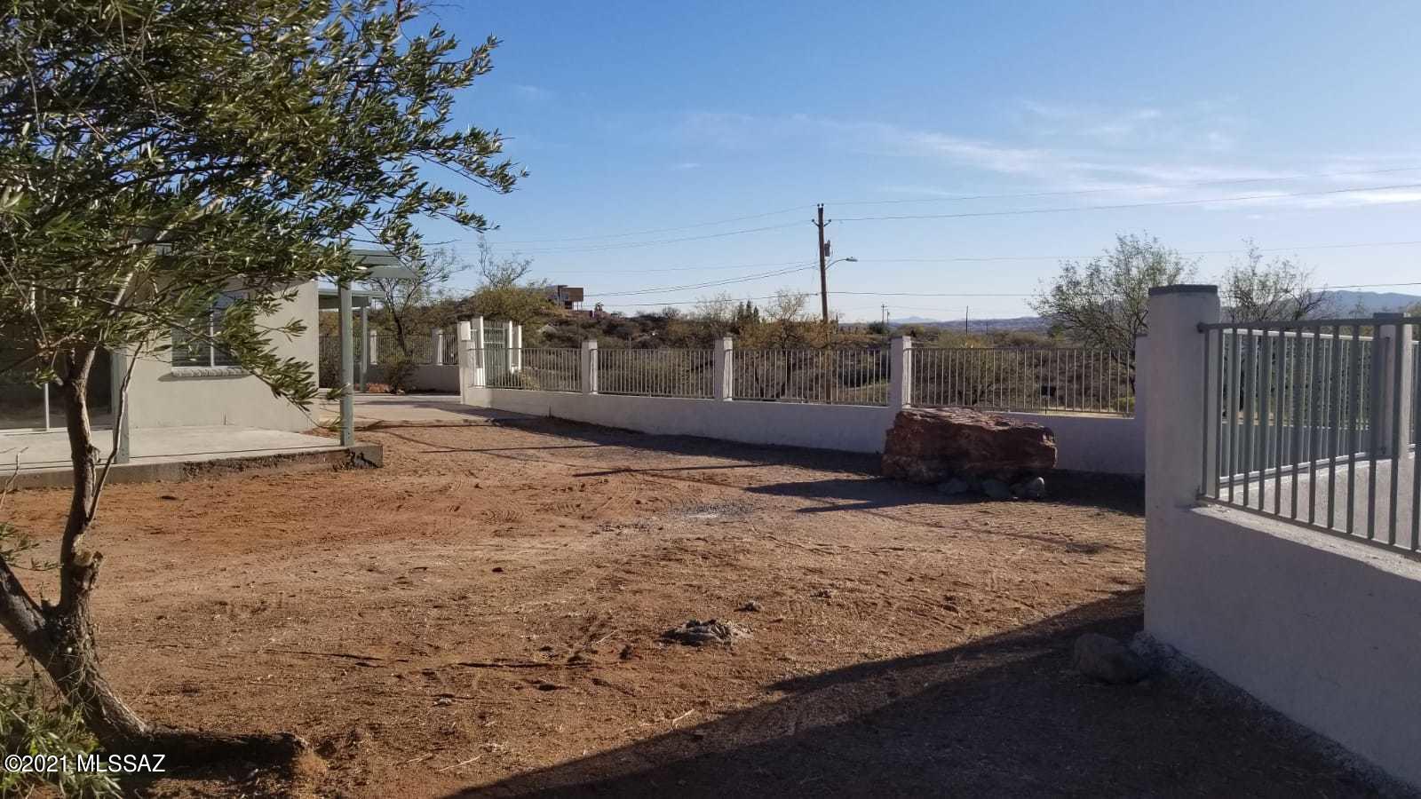 897 Via Savalza Rio Rico, AZ 85648 - Photo 13 of 27 a view of roof deck with two trees and a wooden fence