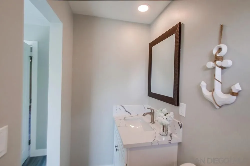 10110 Strathmore Drive Santee, CA 92071 - Photo 23 of 45 a bathroom with a sink a mirror and vanity