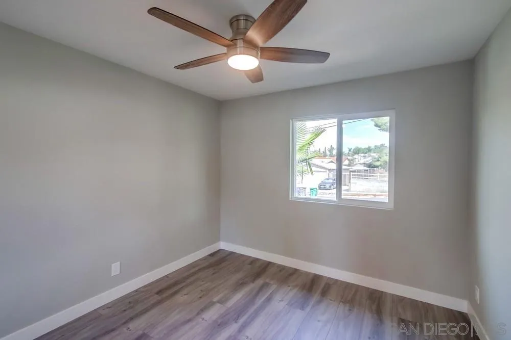 10110 Strathmore Drive Santee, CA 92071 - Photo 25 of 45 an empty room with wooden floor and windows