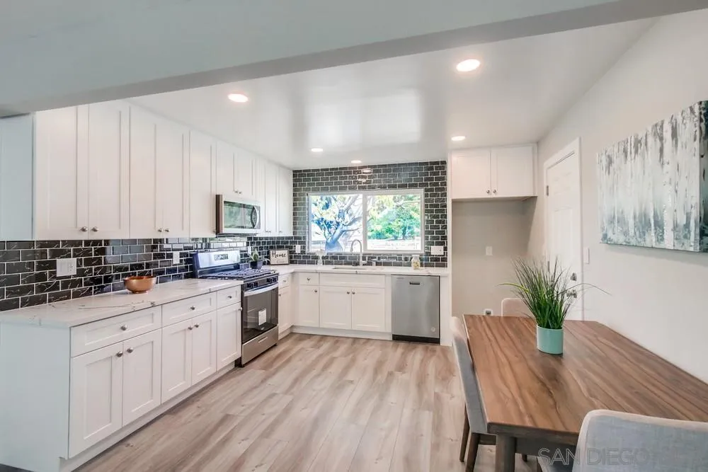 10110 Strathmore Drive Santee, CA 92071 - Photo 7 of 45 a kitchen with sink a microwave and cabinets
