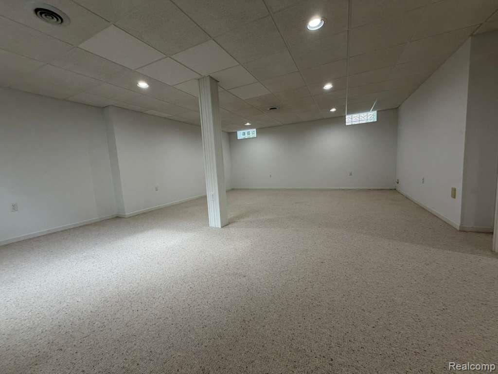 1154 Bluebird Drive Rochester, MI 48307 - Photo 33 of 34 Spacious lower-level room featuring light-toned carpet flooring, recessed lighting, drop ceiling, and opaque block windows