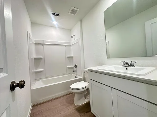 a bathroom with a sink a toilet and a large mirror