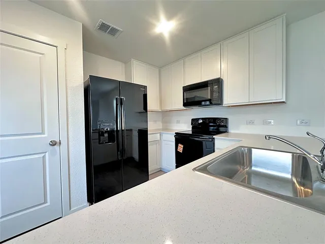 a kitchen with a refrigerator sink and microwave