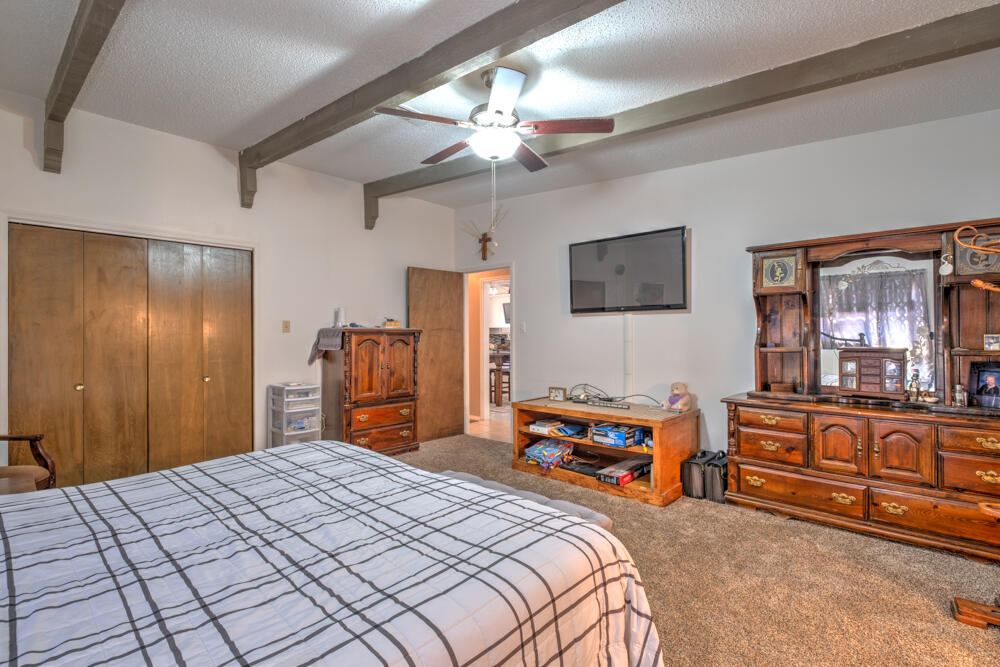 4509 62nd Street Lubbock, TX 79414 - Photo 12 of 20 a bedroom with a bed dresser and flat screen tv