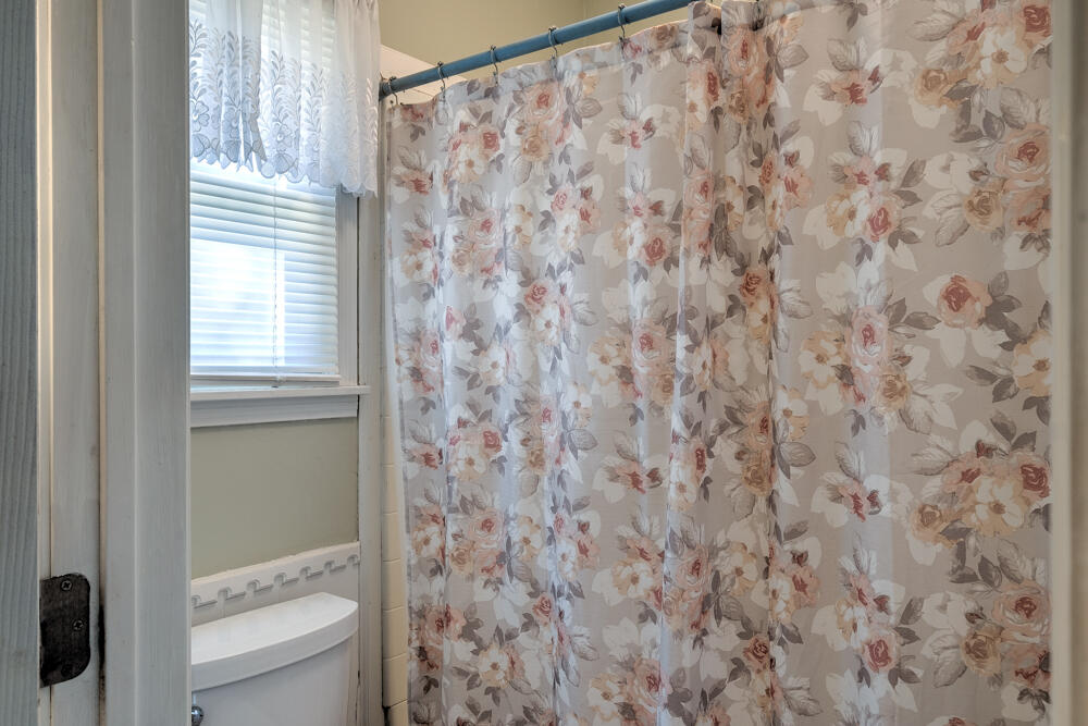 4509 62nd Street Lubbock, TX 79414 - Photo 15 of 20 a bathroom with a toilet and a shower curtain
