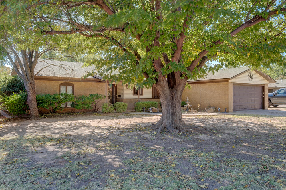 4509 62nd Street Lubbock, TX 79414 - Photo 2 of 20 a front view of a house with a tree and a garage