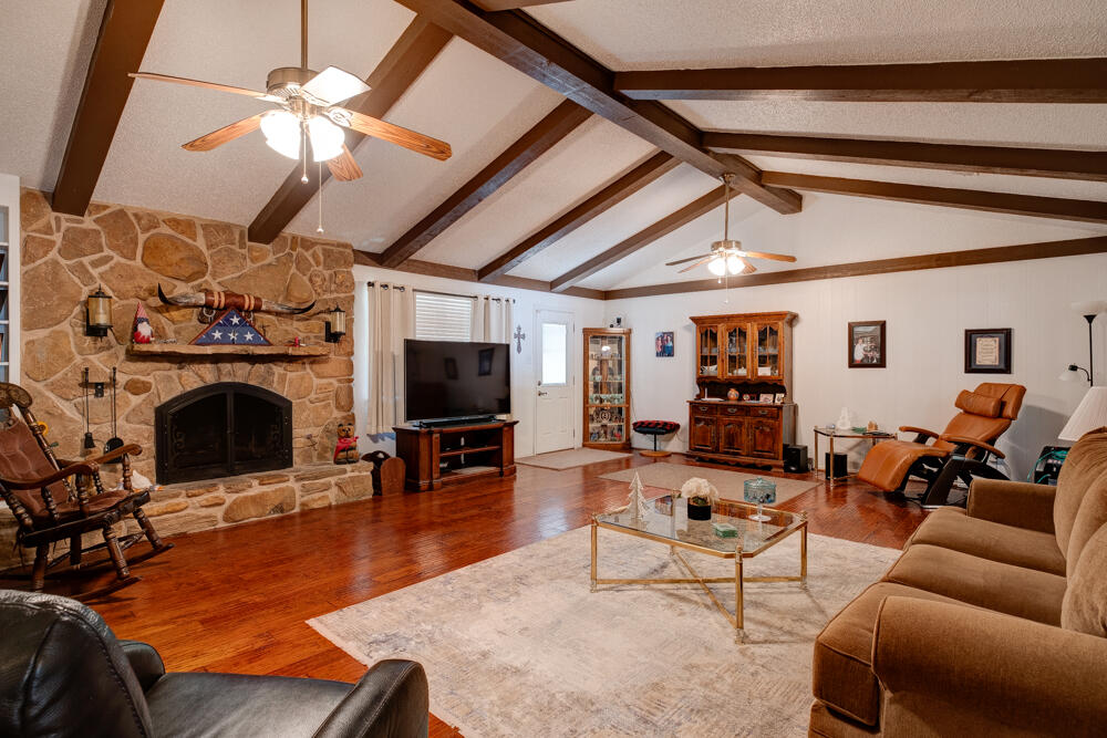 4509 62nd Street Lubbock, TX 79414 - Photo 4 of 20 a living room with furniture a flat screen tv and a fireplace