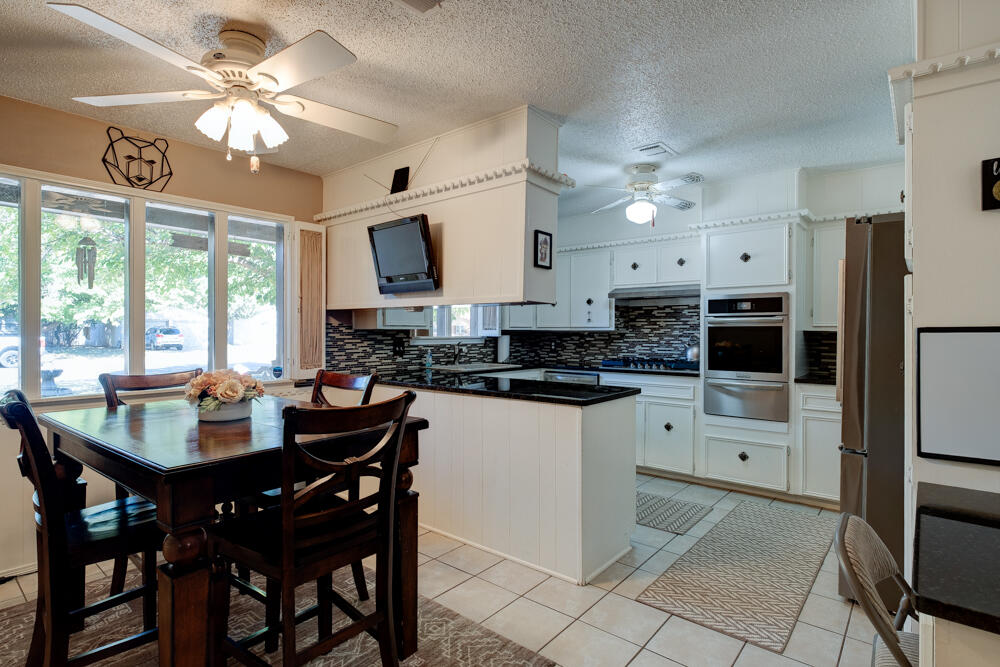 4509 62nd Street Lubbock, TX 79414 - Photo 7 of 20 a kitchen with a dining table cabinets and appliances
